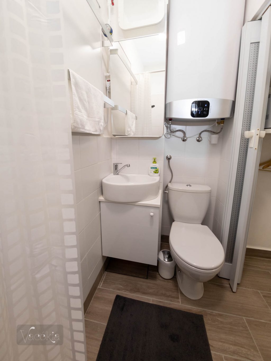 Az elektromos bojler 80 liter vizet melenget, elé lehet kihúzni a tükrös szekrényt, és még egy infrapaneles törülközőszárító is elfér